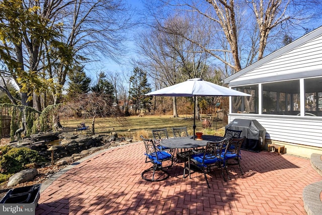 view of patio / terrace with outdoor dining space, a grill, and a sunroom