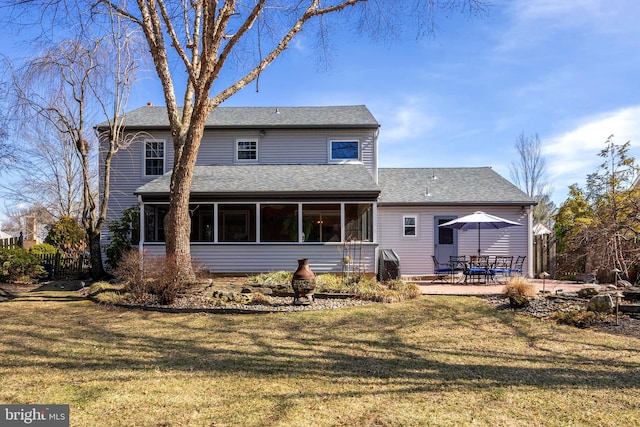 rear view of property featuring a sunroom, a patio area, a yard, and fence