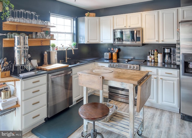 kitchen with white cabinetry, stainless steel appliances, and a sink