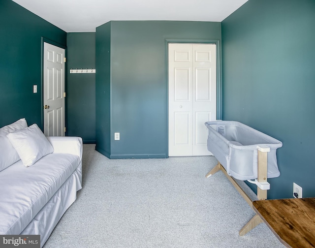 carpeted bedroom featuring baseboards and a closet