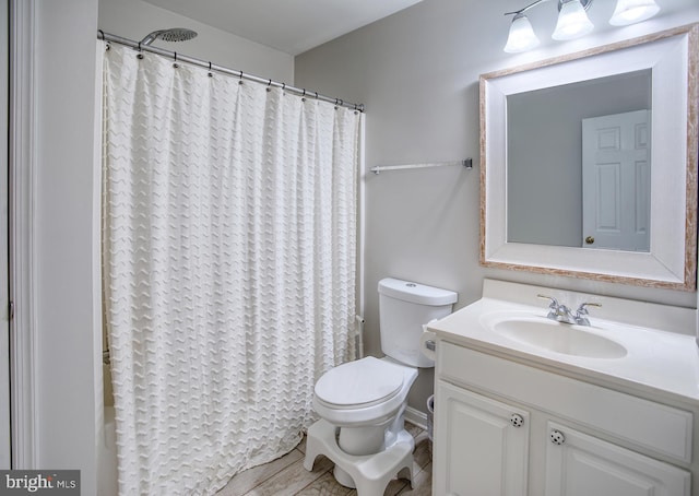 bathroom with curtained shower, vanity, and toilet