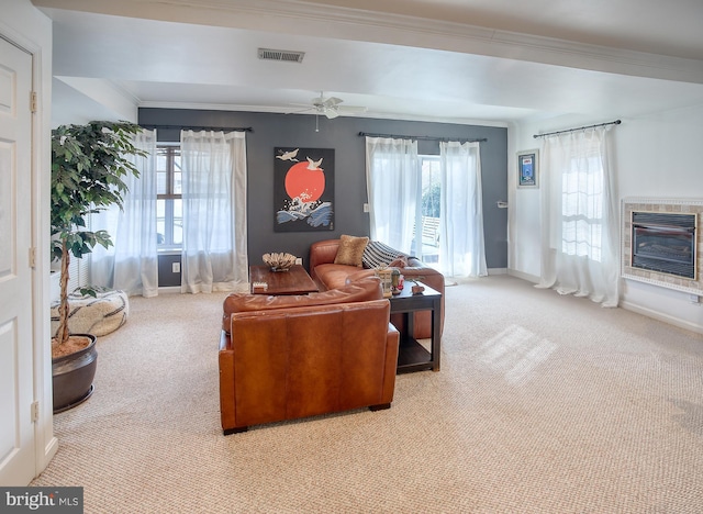 living area featuring baseboards, visible vents, a glass covered fireplace, heating unit, and crown molding