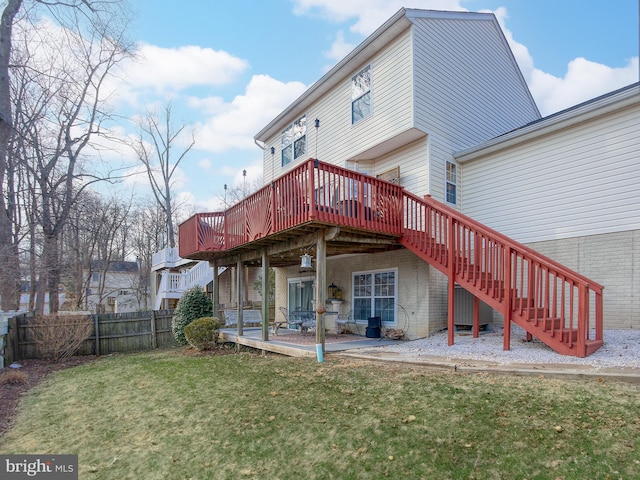 rear view of house with a yard, stairway, a patio area, fence, and a wooden deck