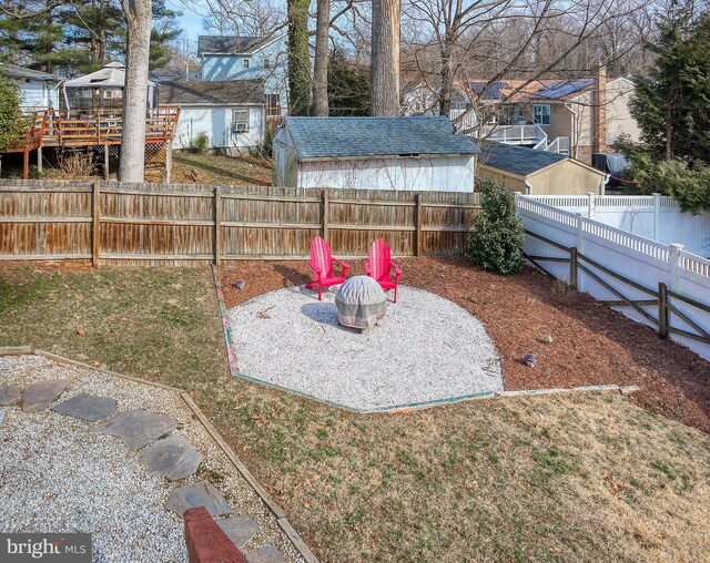 view of yard with a residential view, a fenced backyard, and an outdoor fire pit