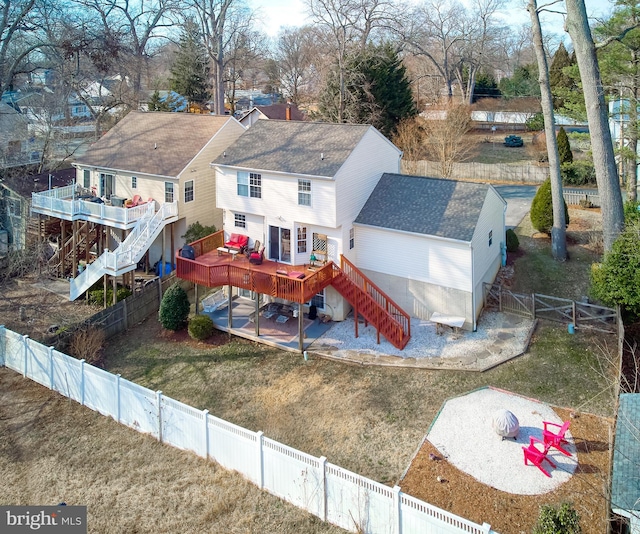 rear view of house with stairs, a deck, a lawn, and a fenced backyard