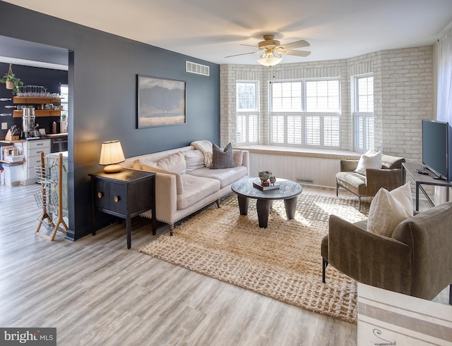 living area featuring ceiling fan, wood finished floors, and visible vents