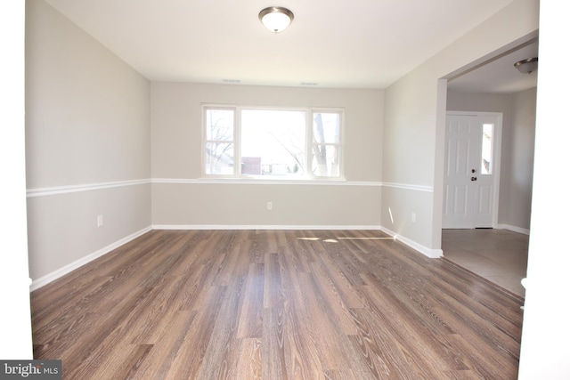 spare room with wood finished floors and baseboards