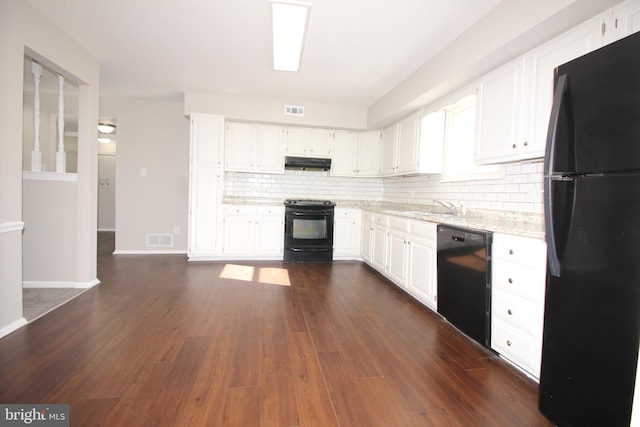 kitchen featuring visible vents, dark wood finished floors, under cabinet range hood, and black appliances