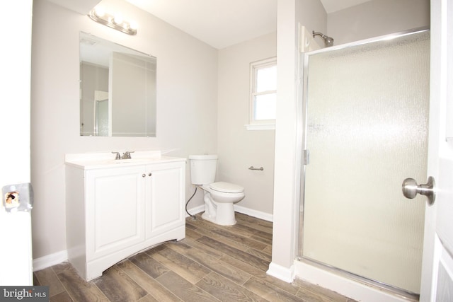 full bathroom with wood tiled floor, toilet, a shower stall, and vanity