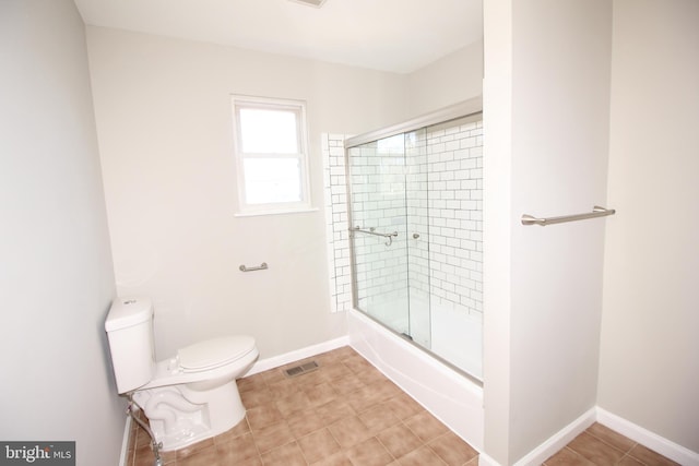 bathroom featuring bath / shower combo with glass door, tile patterned floors, toilet, and baseboards