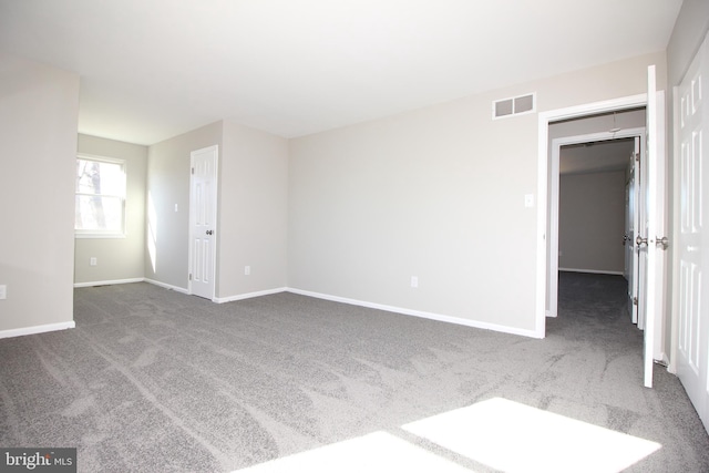 carpeted empty room featuring visible vents and baseboards