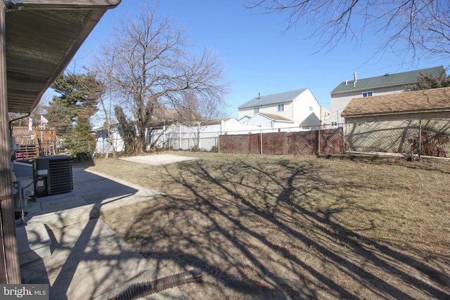 view of yard with a patio area, a fenced backyard, and central AC