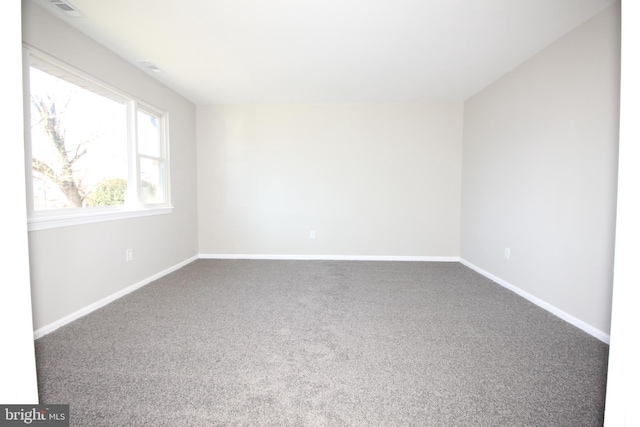 empty room featuring visible vents, baseboards, and carpet flooring