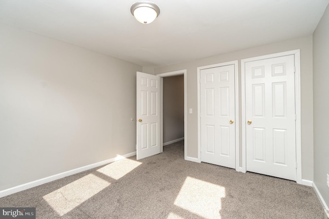 unfurnished bedroom with carpet floors and baseboards