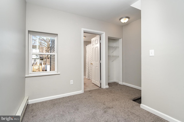 unfurnished bedroom with baseboards, ensuite bath, baseboard heating, carpet flooring, and a closet