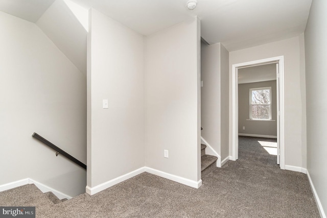 corridor featuring carpet flooring, stairway, and baseboards