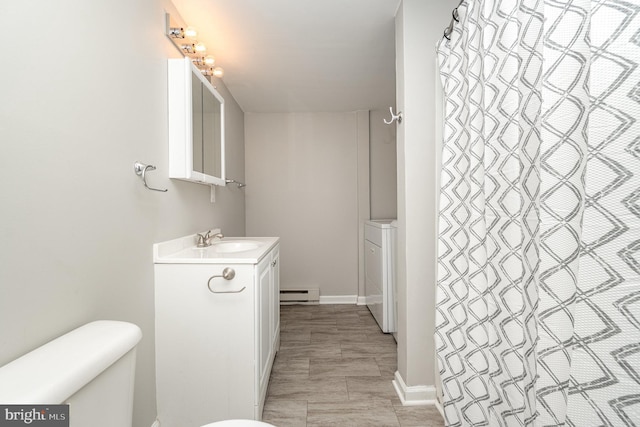 full bathroom with a baseboard radiator, toilet, vanity, baseboards, and washer / clothes dryer