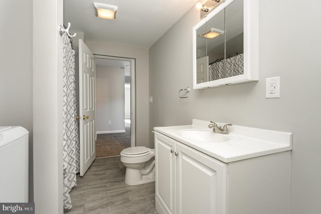 full bathroom featuring washer / clothes dryer, vanity, and toilet