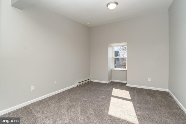 spare room with a baseboard heating unit, dark carpet, and baseboards