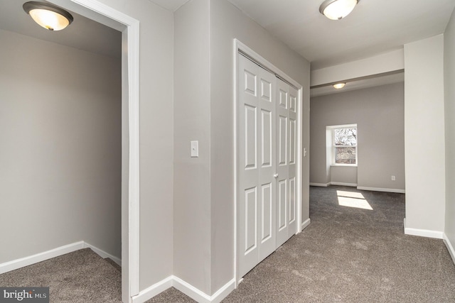 hallway featuring carpet flooring and baseboards