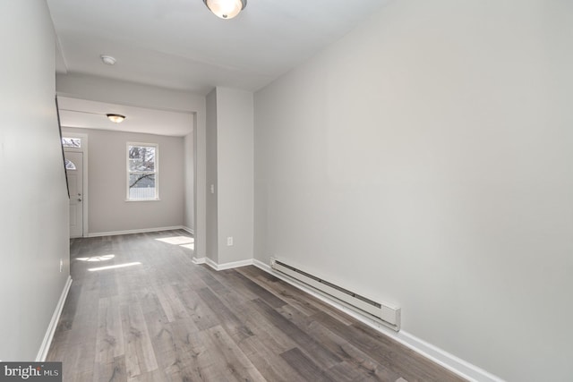 interior space with baseboards, baseboard heating, and wood finished floors