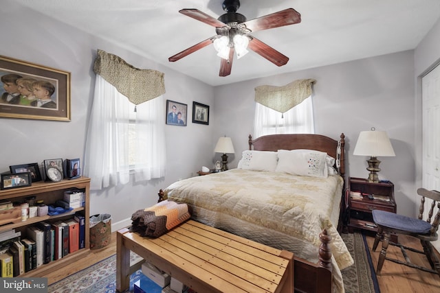 bedroom with wood finished floors, baseboards, and ceiling fan