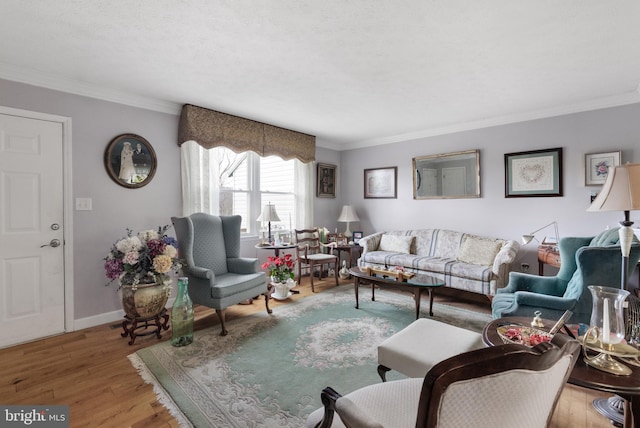 living area with wood finished floors, baseboards, and ornamental molding