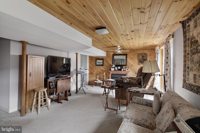 carpeted living room with ceiling fan, a wealth of natural light, wooden walls, and wooden ceiling