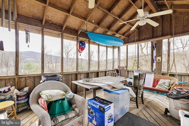 sunroom featuring vaulted ceiling, plenty of natural light, a ceiling fan, and a mountain view