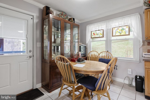 dining space featuring baseboards, light tile patterned flooring, and crown molding