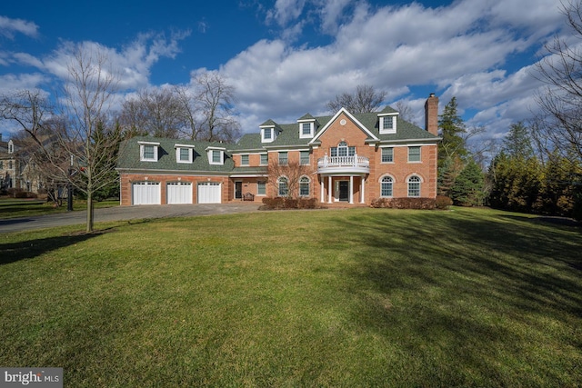 view of front of property featuring a garage, a chimney, aphalt driveway, a front yard, and brick siding