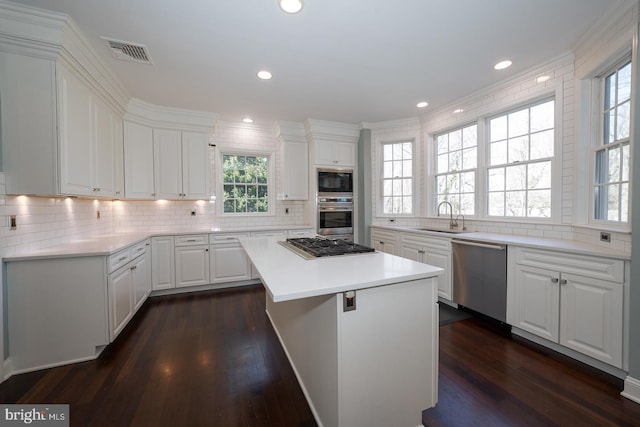 kitchen featuring dark wood-type flooring, a sink, visible vents, white cabinets, and appliances with stainless steel finishes