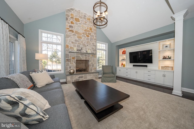 living area with a healthy amount of sunlight, decorative columns, a fireplace, and high vaulted ceiling