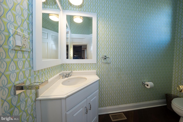 bathroom featuring visible vents, baseboards, and wallpapered walls