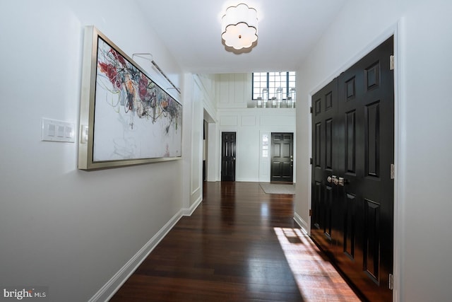 foyer entrance with wood finished floors and baseboards