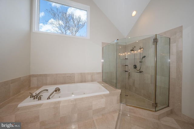 bathroom with lofted ceiling, a jetted tub, and a shower stall