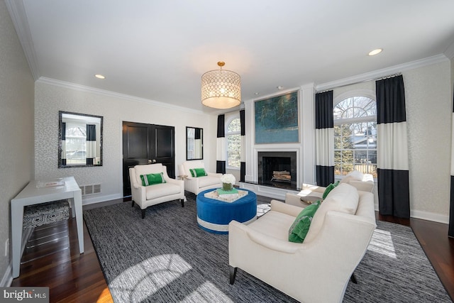 living area featuring plenty of natural light, wood finished floors, visible vents, and baseboards