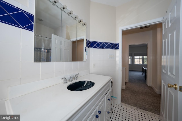 bathroom with visible vents, tile walls, and vanity