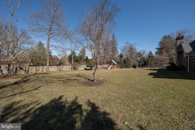 view of yard with fence and a playground