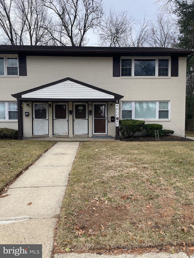 view of front of home featuring brick siding and a front lawn