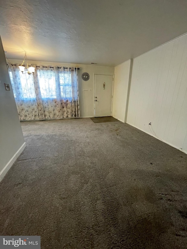 unfurnished living room with carpet and a chandelier