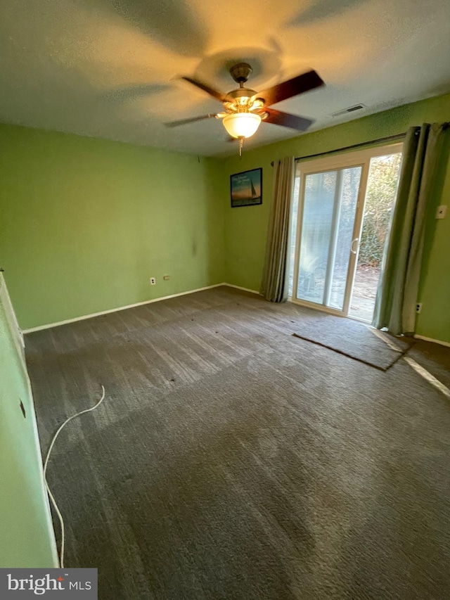 carpeted empty room with visible vents, ceiling fan, a textured ceiling, and baseboards