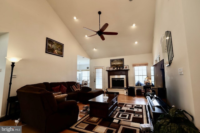 living area featuring wood finished floors, high vaulted ceiling, recessed lighting, ceiling fan, and a glass covered fireplace