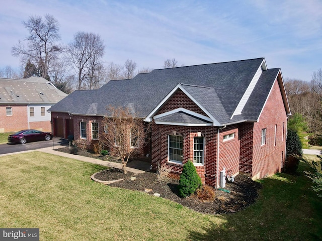 view of front of house with brick siding, an attached garage, a shingled roof, a front lawn, and driveway