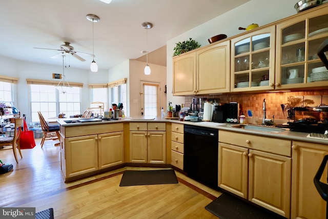 kitchen with light wood finished floors, a peninsula, a sink, light brown cabinetry, and black dishwasher