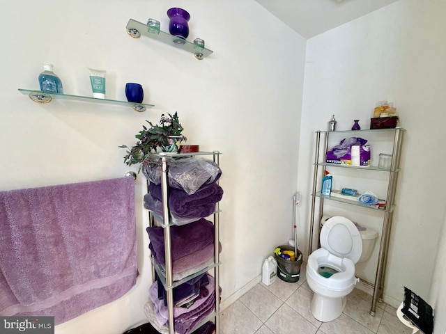 bathroom with tile patterned floors, toilet, and baseboards