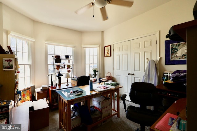 office featuring dark carpet, a wealth of natural light, and ceiling fan