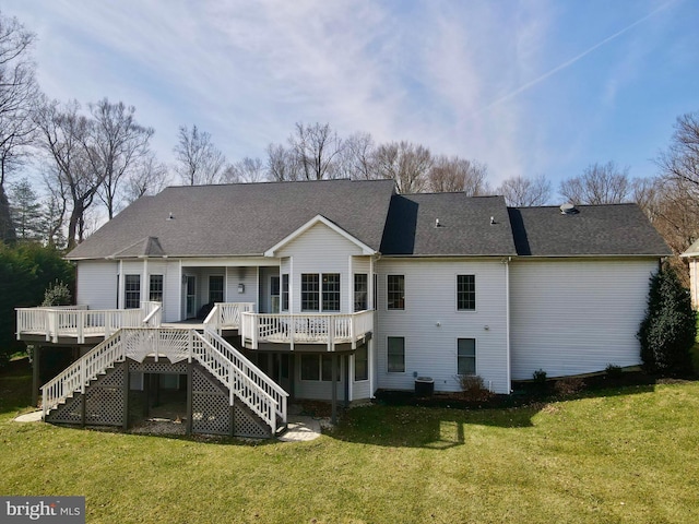 back of house featuring a lawn, a wooden deck, and stairs