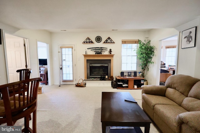 living area with carpet floors and a glass covered fireplace