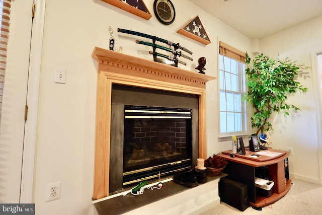 interior details with baseboards, carpet, and a glass covered fireplace